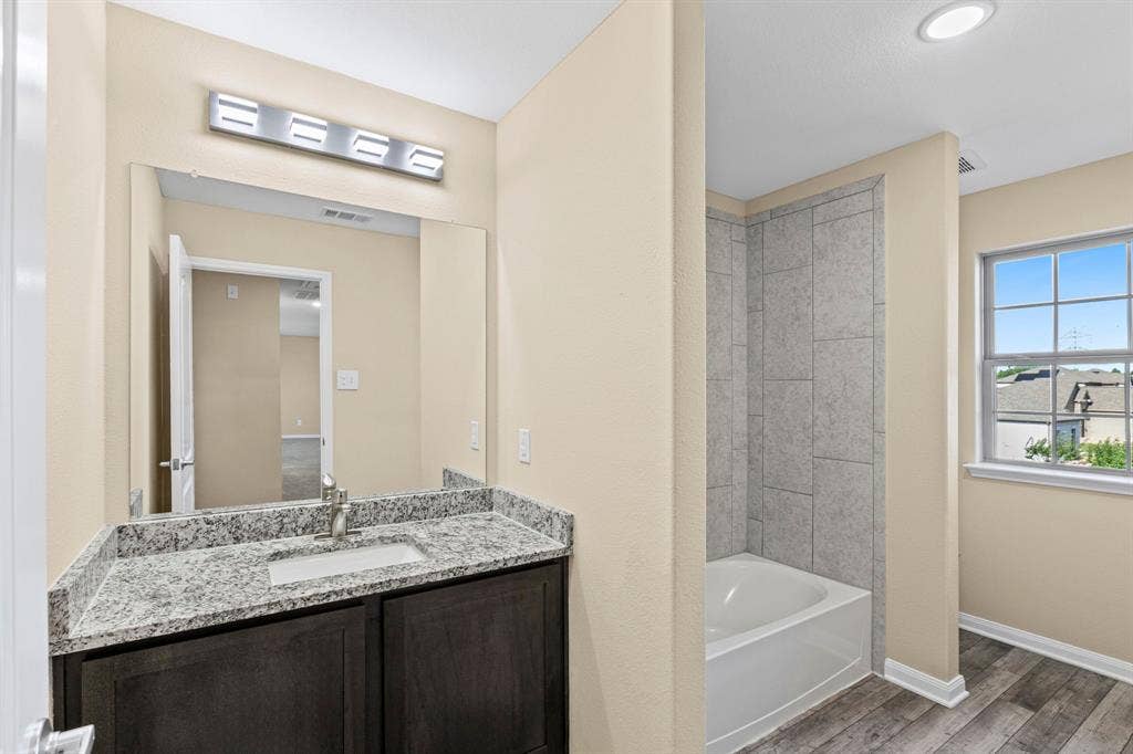 1516 Kinglet Street, DeSoto, TX 75115 Bathroom featuring a dark wood-finish vanity with a light-colored granite countertop and undermount sink