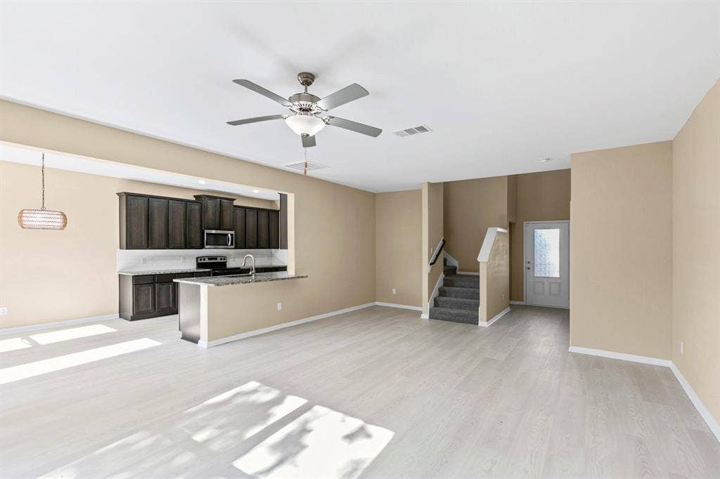 1516 Kinglet Street, DeSoto, TX 75115 Open-concept living area featuring light wood-finish flooring, a contemporary ceiling fan, and recessed lighting
