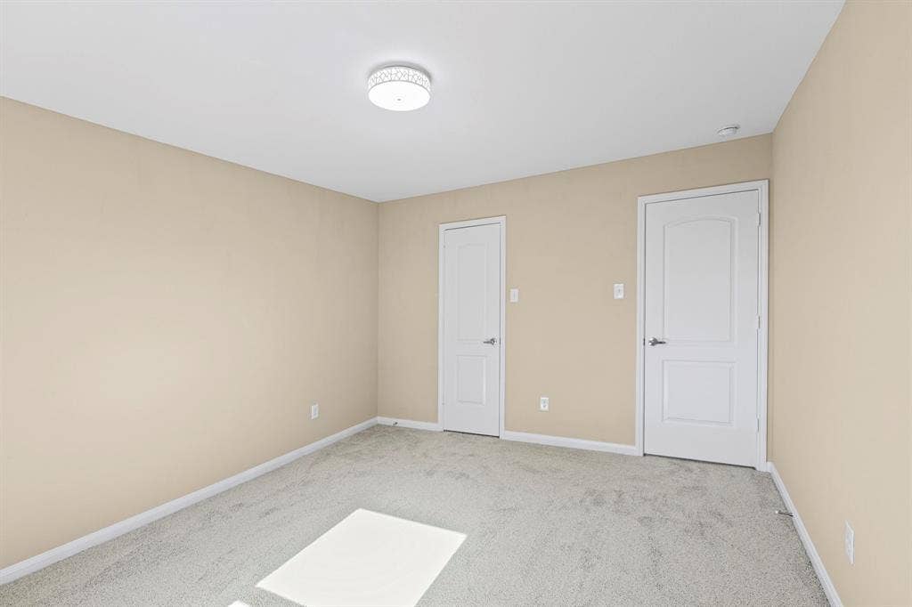 1516 Kinglet Street, DeSoto, TX 75115 Neutral-toned interior featuring two white paneled doors, light grey carpeting, and a flush mount ceiling light fixture