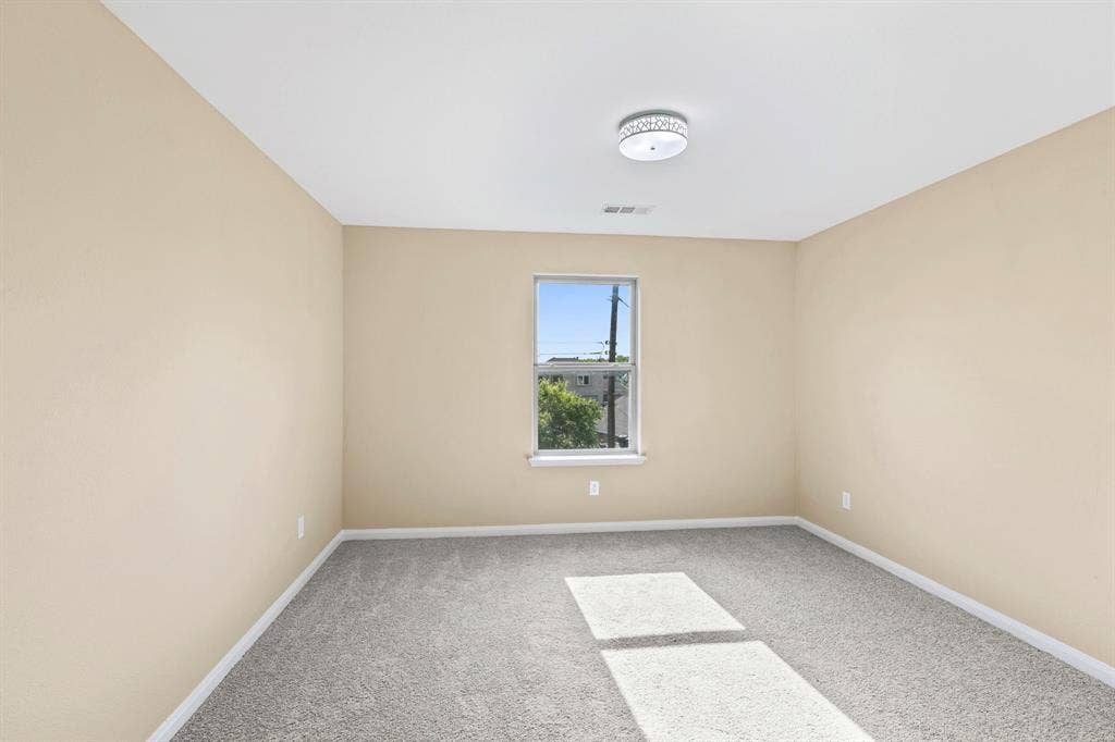 1516 Kinglet Street, DeSoto, TX 75115 Carpeted room with a single window, neutral-toned walls, and a ceiling-mounted light fixture