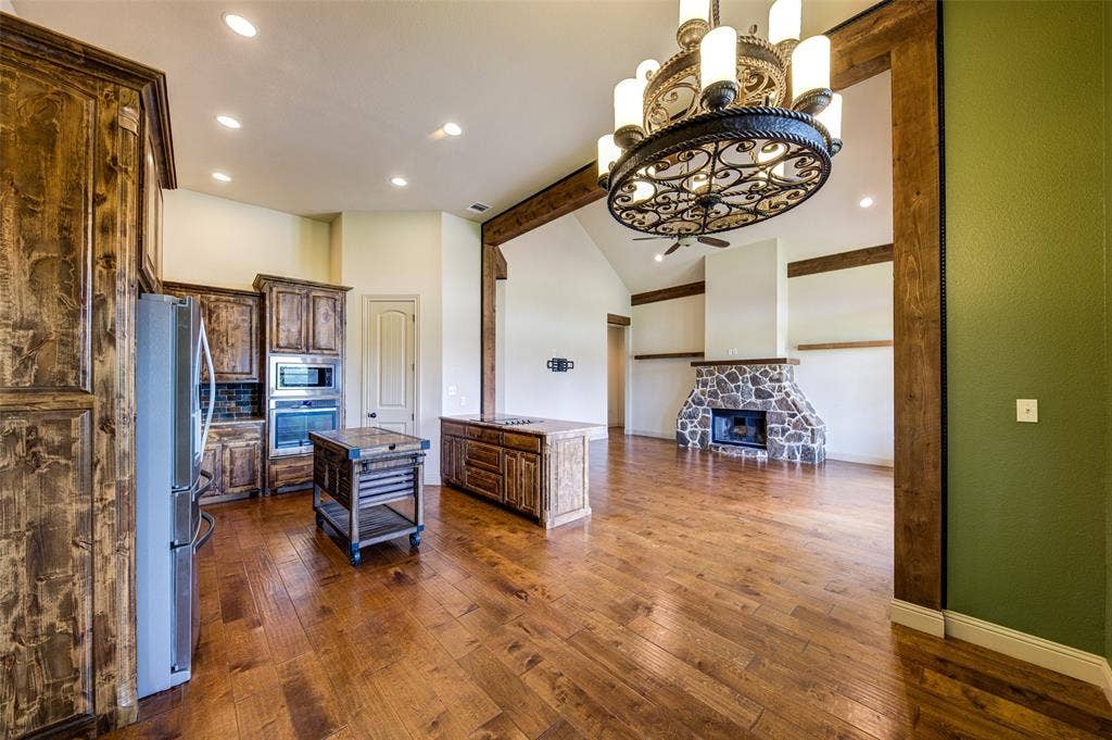 245 Fm 407 W, Argyle, TX 76226 Kitchen and Dining area with a chandelier, dark wood-type flooring, a fireplace, stainless steel appliances, and beamed ceiling