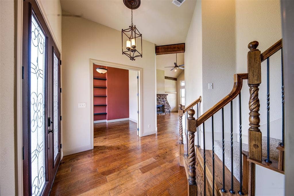245 Fm 407 W, Argyle, TX 76226 Entrance foyer with vaulted ceiling, stairs, wood finished floors, a ceiling fan, and a stone fireplace