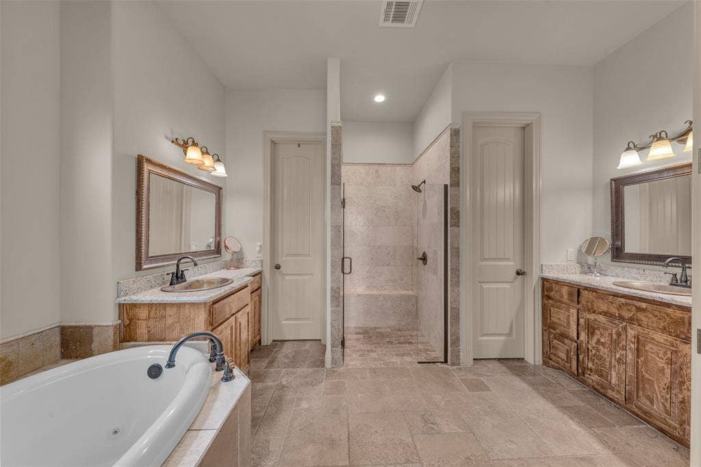 245 Fm 407 W, Argyle, TX 76226 Bathroom featuring a shower stall, a large tub, two granite vanities, stone tile floors, and recessed lighting