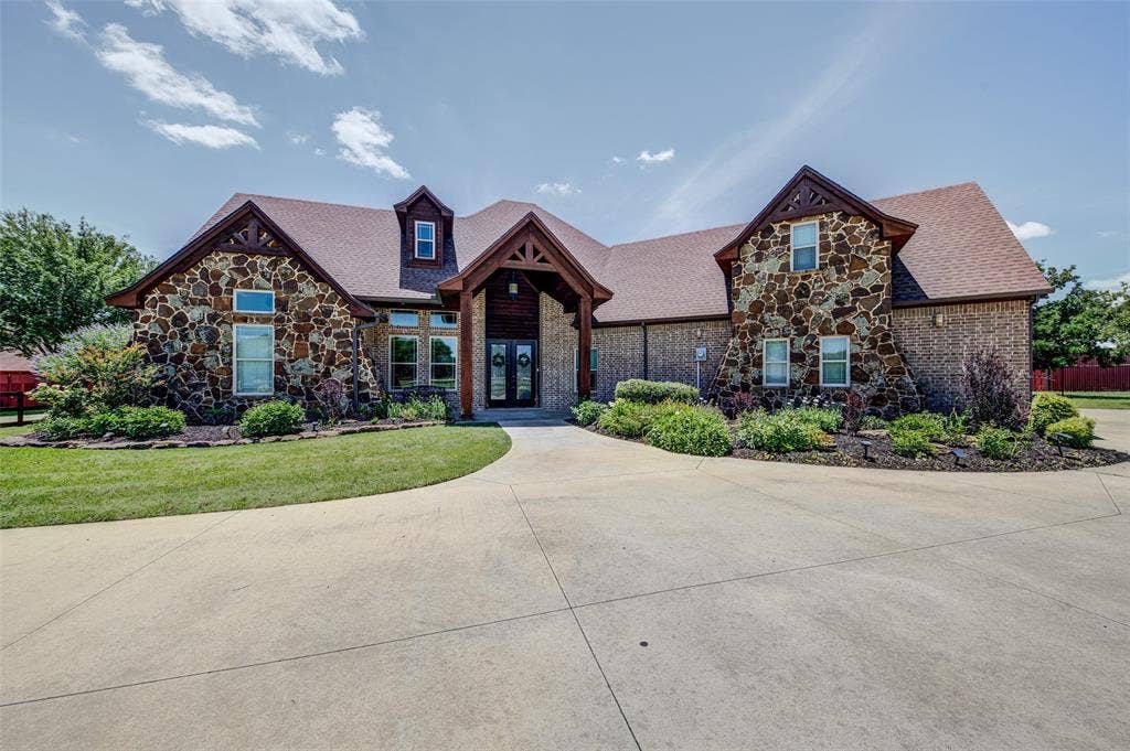 245 Fm 407 W, Argyle, TX 76226 Craftsman-style house featuring french doors, stone siding, brick siding, a front lawn, and a shingled roof