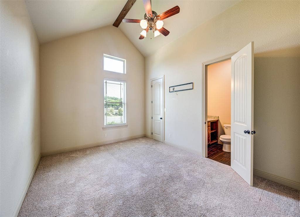 245 Fm 407 W, Argyle, TX 76226 Unfurnished bedroom featuring carpet floors, high vaulted ceiling, ensuite bath, beam ceiling, and ceiling fan