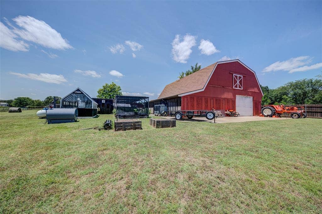 245 Fm 407 W, Argyle, TX 76226 View of green lawn with a barn, driveway, a detached garage, and an outdoor structure