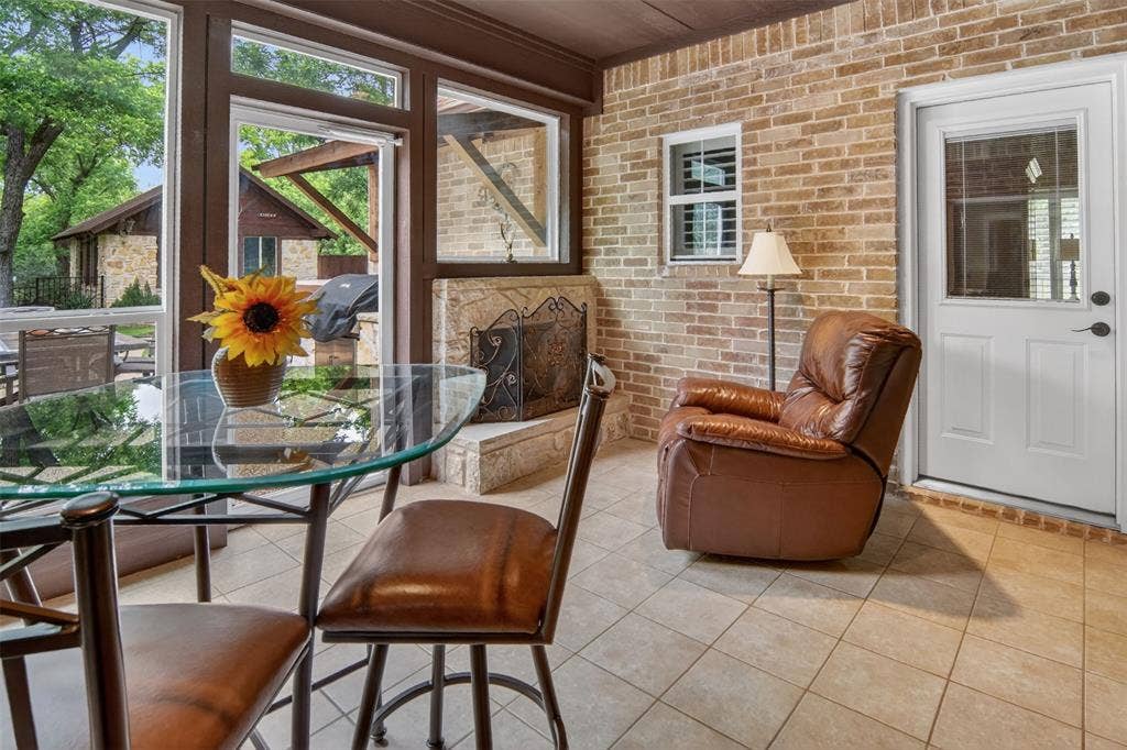 Enclosed patio with tile flooring, fireplace and lovely view of back yard.
