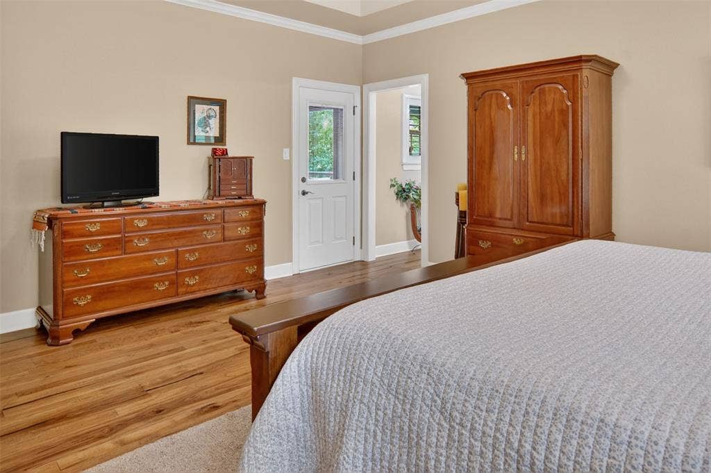 Additional view of primary bedroom with door leaving to enclosed patio and rear yard.