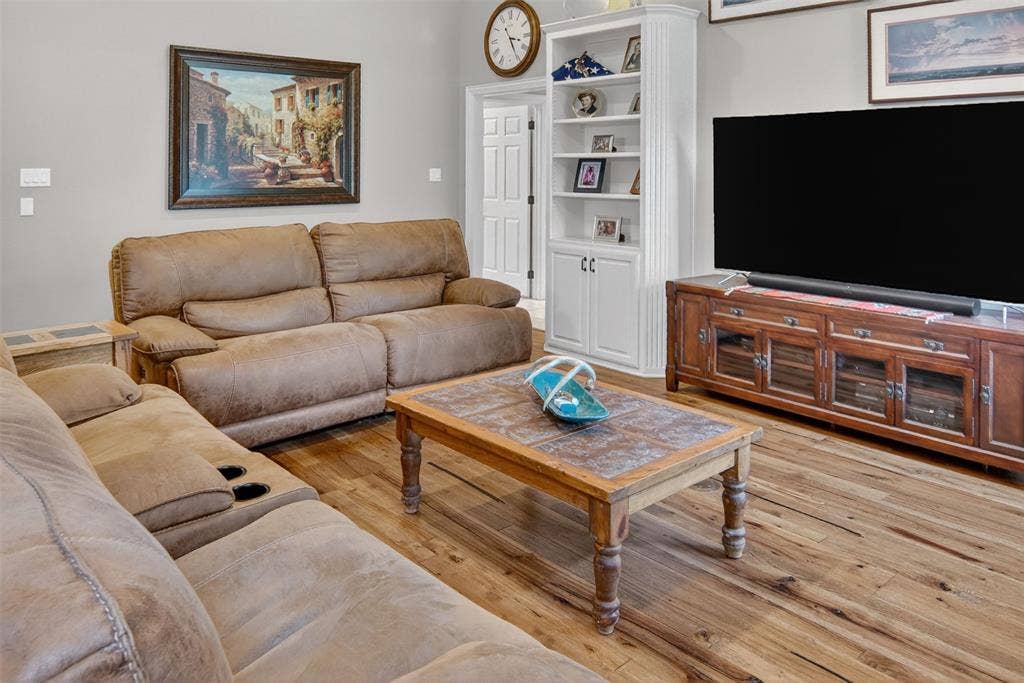 Inviting family room with wood flooring, built-ins, and fireplace.