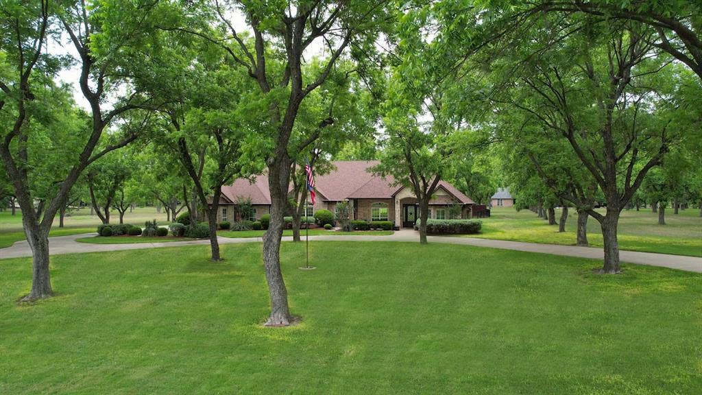 Lovely treed yard with circular drive.