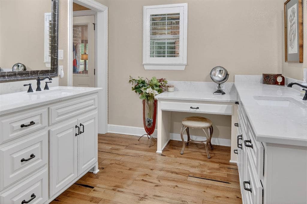 Recently updated primary bath with wood flooring and double vanities.