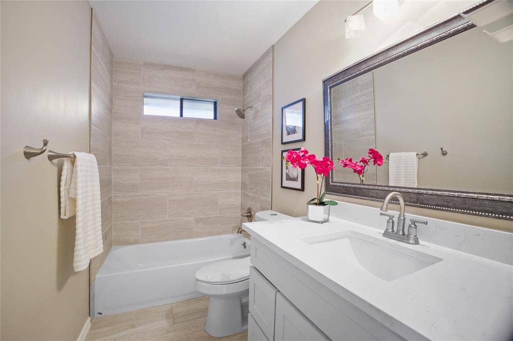 3228 Anchor Drive, Plano, TX 75023 Bathroom featuring a white vanity with an integrated sink, polished chrome faucet, and a large framed mirror