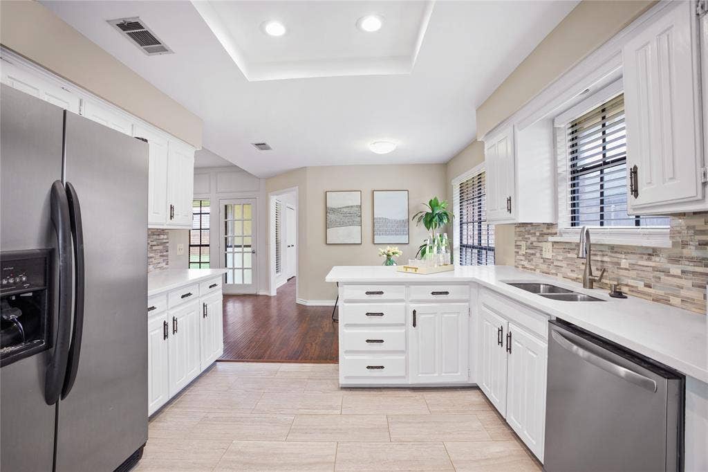 3228 Anchor Drive, Plano, TX 75023 Kitchen featuring white cabinetry, light countertops, and a mosaic tile backsplash