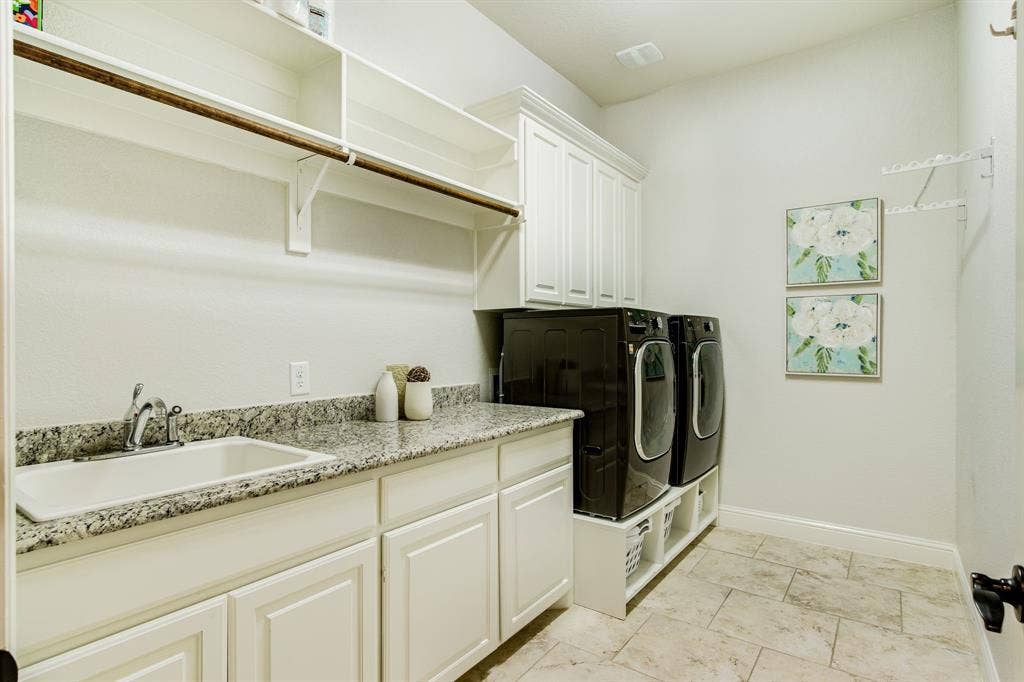 Oh my, what a laundry space!  Counter space, cabinets, built in pedestals with basket storage cubbies!