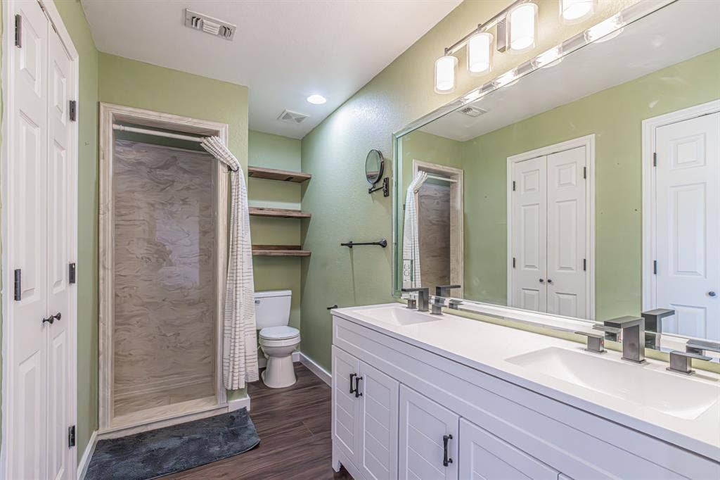 204 S Spring Branch Trail, Springtown, TX 76082 Dual vanity with integrated sinks and contemporary faucets, full-width mirror, and overhead vanity lighting