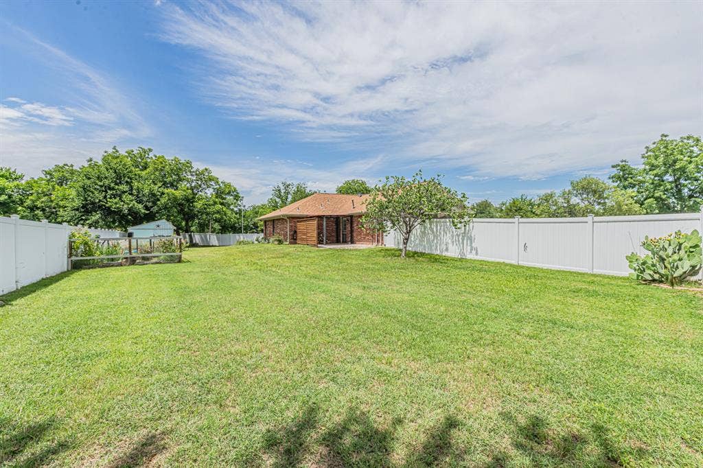 204 S Spring Branch Trail, Springtown, TX 76082 Expansive backyard featuring a lush lawn, privacy fencing, and mature trees