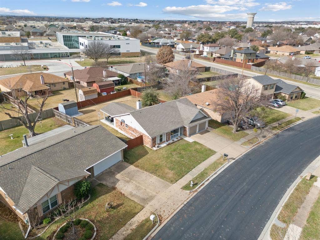 7629 Cedarhill Road, Watauga, TX 76148 Aerial perspective showcasing a residential neighborhood with single-story homes, asphalt streets, and mature trees