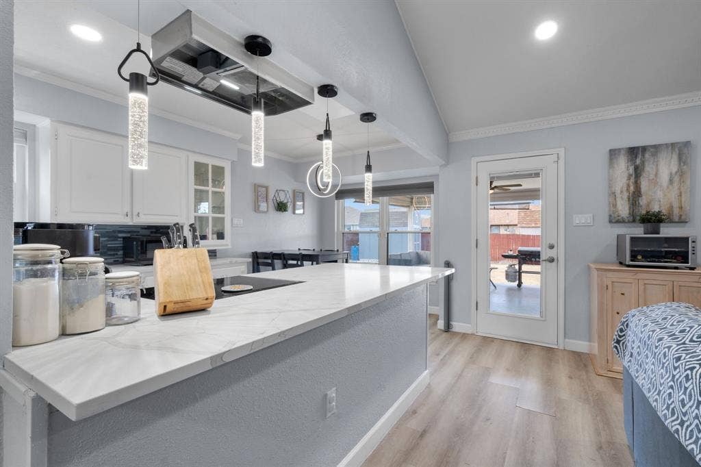 7629 Cedarhill Road, Watauga, TX 76148 Modern kitchen island featuring a light-toned countertop and built-in cooktop