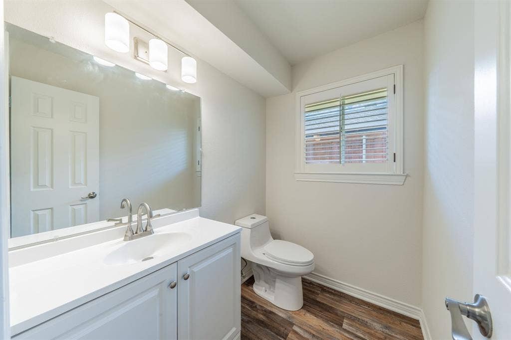 2212 Vickers Drive, Plano, TX 75075 Half Bathroom with a white vanity featuring a single sink, brushed nickel faucet, and white cabinetry