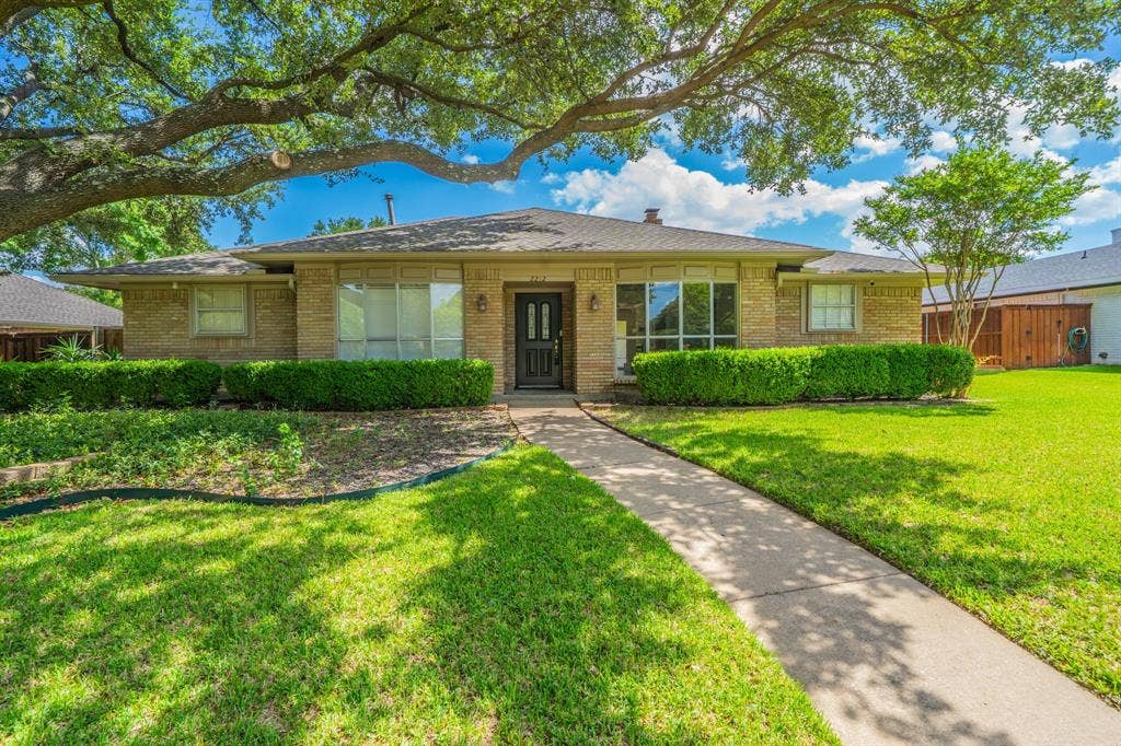 2212 Vickers Drive, Plano, TX 75075 Traditional brick-clad exterior featuring a prominent front lawn with a concrete pathway leading to the entry