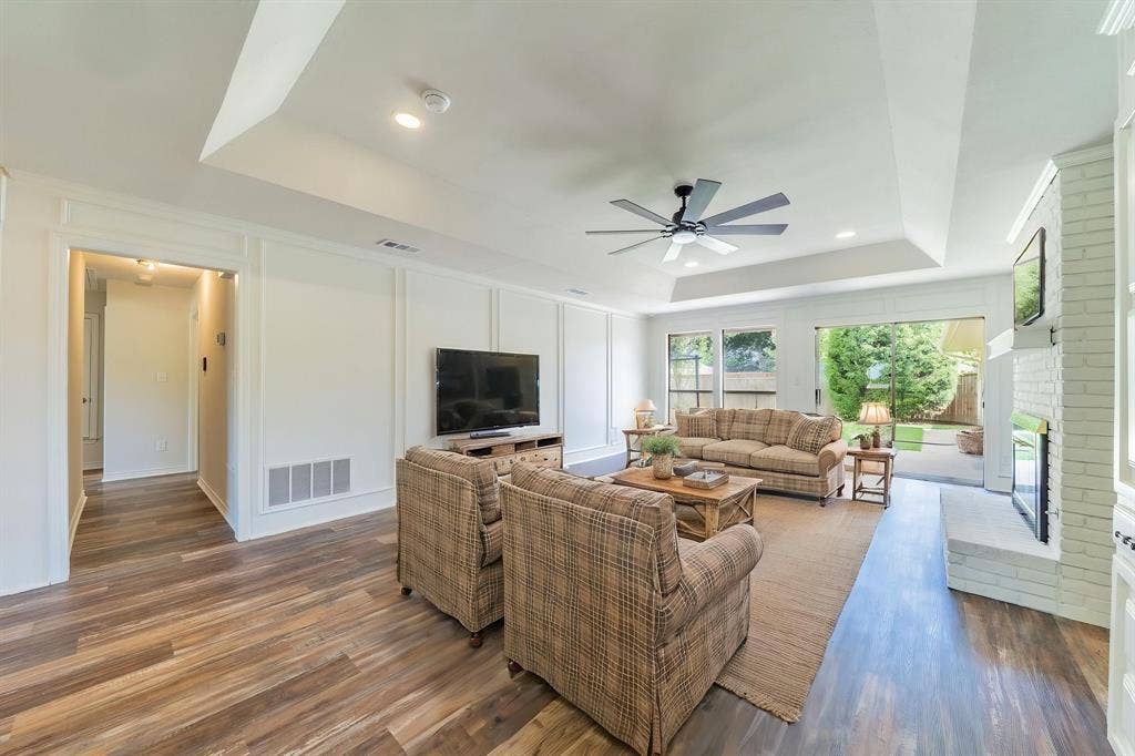 2212 Vickers Drive, Plano, TX 75075 Virtually Staged. Living area featuring wood-finish flooring, a tray ceiling with a ceiling fan, and recessed lighting