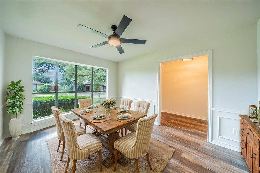 2212 Vickers Drive, Plano, TX 75075 Virtually Staged. Spacious room featuring a large picture window, wood-finish flooring, and crown molding