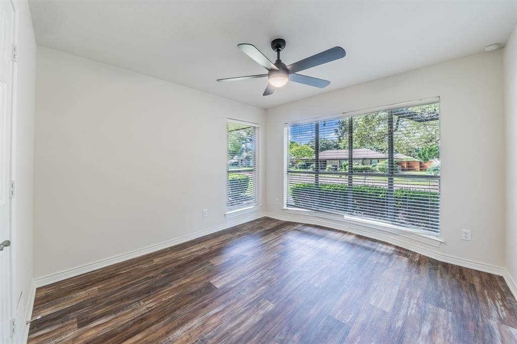 2212 Vickers Drive, Plano, TX 75075 Spacious room featuring wood-finish flooring, white walls, and a ceiling fan with integrated lighting