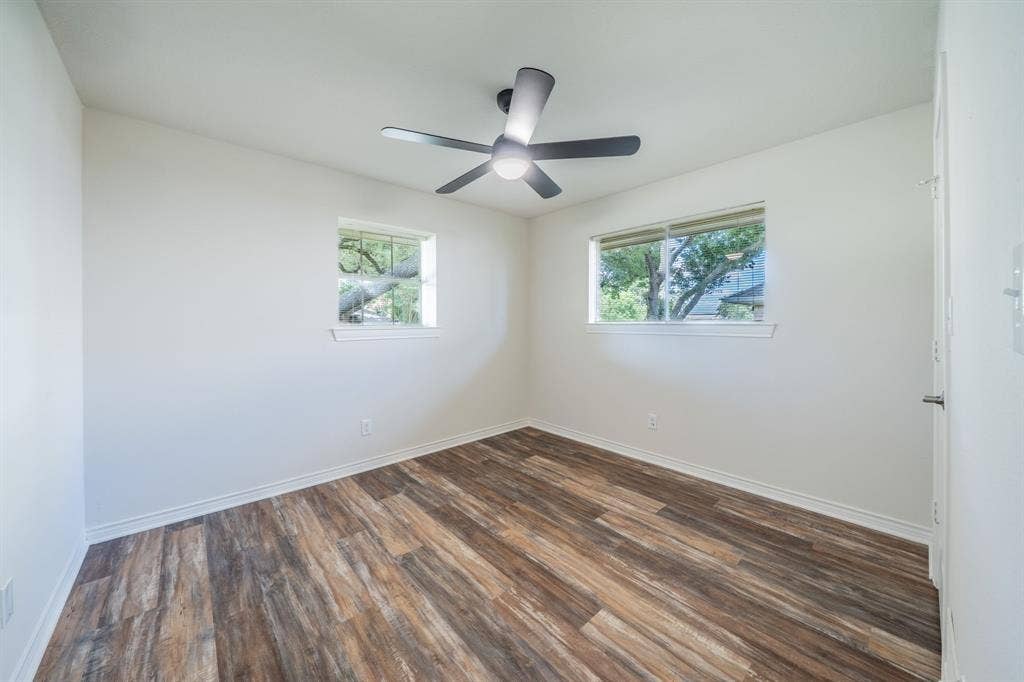 2212 Vickers Drive, Plano, TX 75075 Interior room featuring two windows, wood-finish flooring, a contemporary ceiling fan, and white baseboards