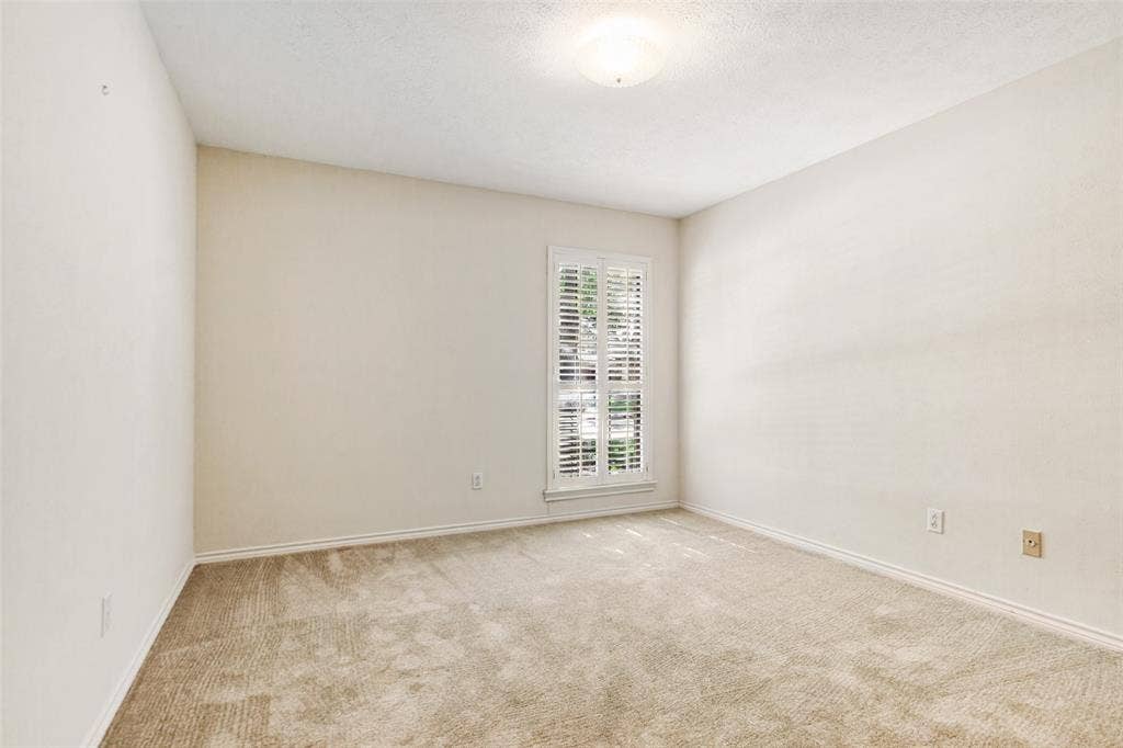 915 Grinnell Drive, Richardson, TX 75081 915 Grinnell Dr. - Bedroom featuring a front-facing window with a plantation shutter, providing natural light and a polished architectural detail.