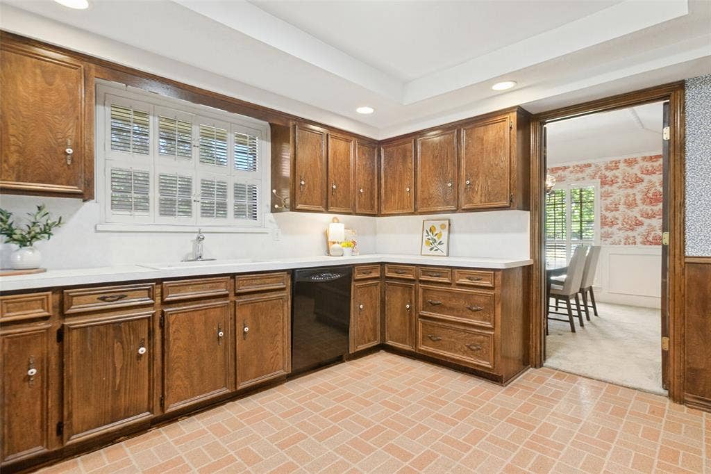 915 Grinnell Drive, Richardson, TX 75081 915 Grinnell Dr. - Kitchen featuring a tray ceiling with recessed lighting, a solar tube for additional natural light, traditional wood cabinetry with abundant storage, double ovens, and a large window above the kitchen sink.
