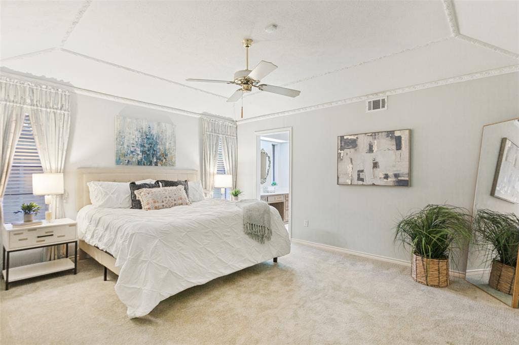 915 Grinnell Drive, Richardson, TX 75081 915 Grinnell Dr. - Spacious primary bedroom featuring a gently sloped ceiling with elegant crown molding and a private en-suite bathroom.