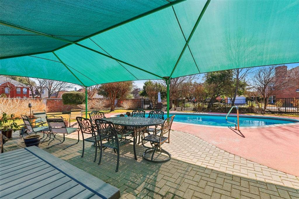 5949 River Bend Drive, Benbrook, TX 76132 Outdoor living space featuring a large swimming pool, brick paver patio, and a green shade canopy