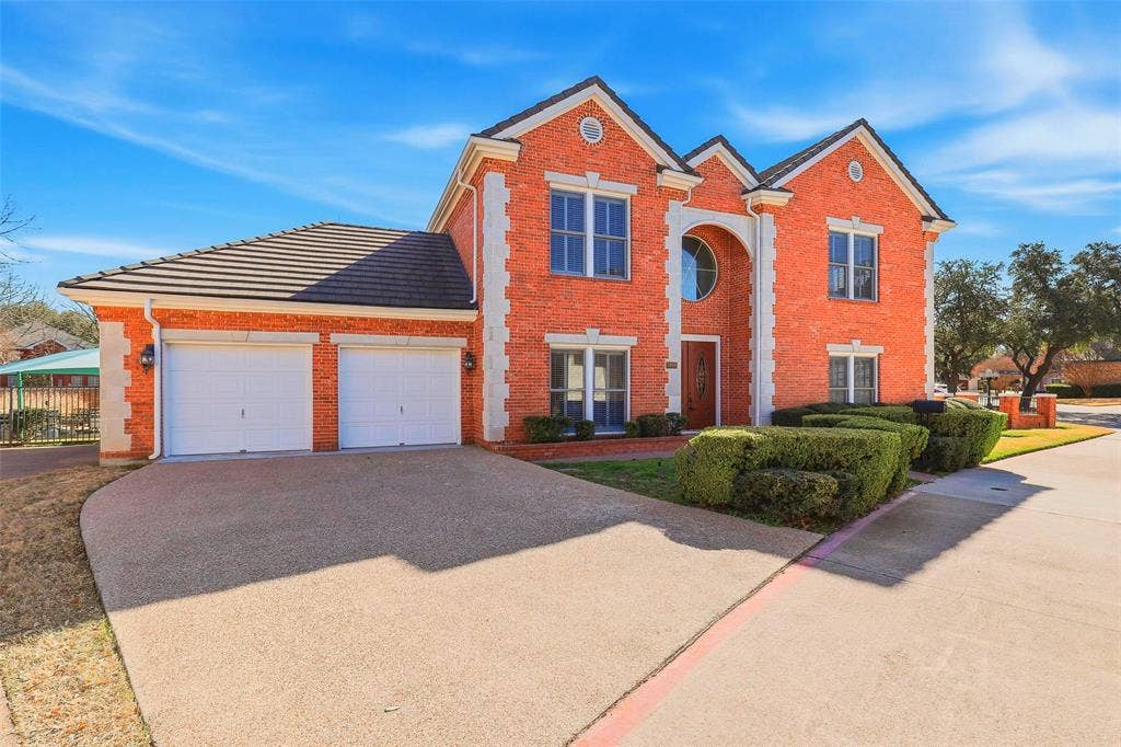 5949 River Bend Drive, Benbrook, TX 76132 Brick exterior with white stone accents, a tile roof, and a two-car garage