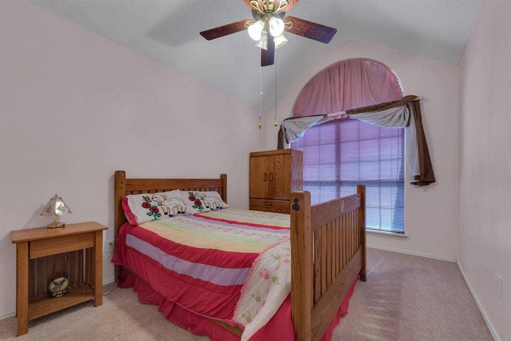 4622 Devonshire Drive, Grand Prairie, TX 75052 Bedroom featuring a vaulted ceiling, ceiling fan with integrated lighting, and an arched window with blinds