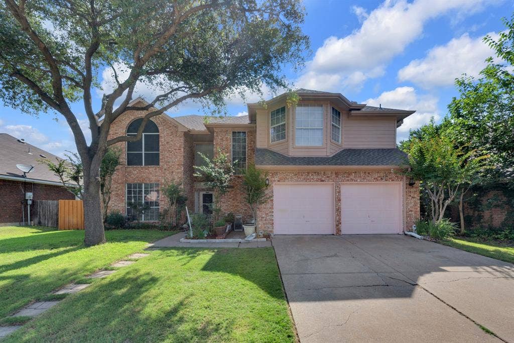 4622 Devonshire Drive, Grand Prairie, TX 75052 Two-story residence featuring a brick facade with complementary siding, a two-car garage, and a concrete driveway
