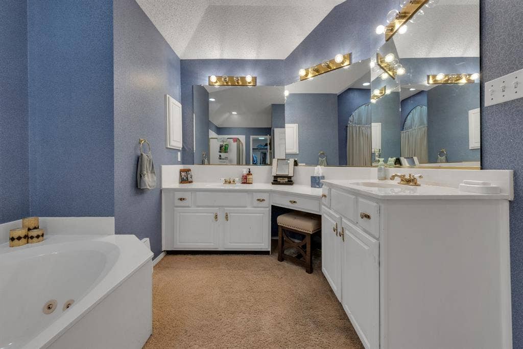 4622 Devonshire Drive, Grand Prairie, TX 75052 Bathroom featuring a corner soaking tub, dual vanity with individual sinks, and an integrated makeup vanity