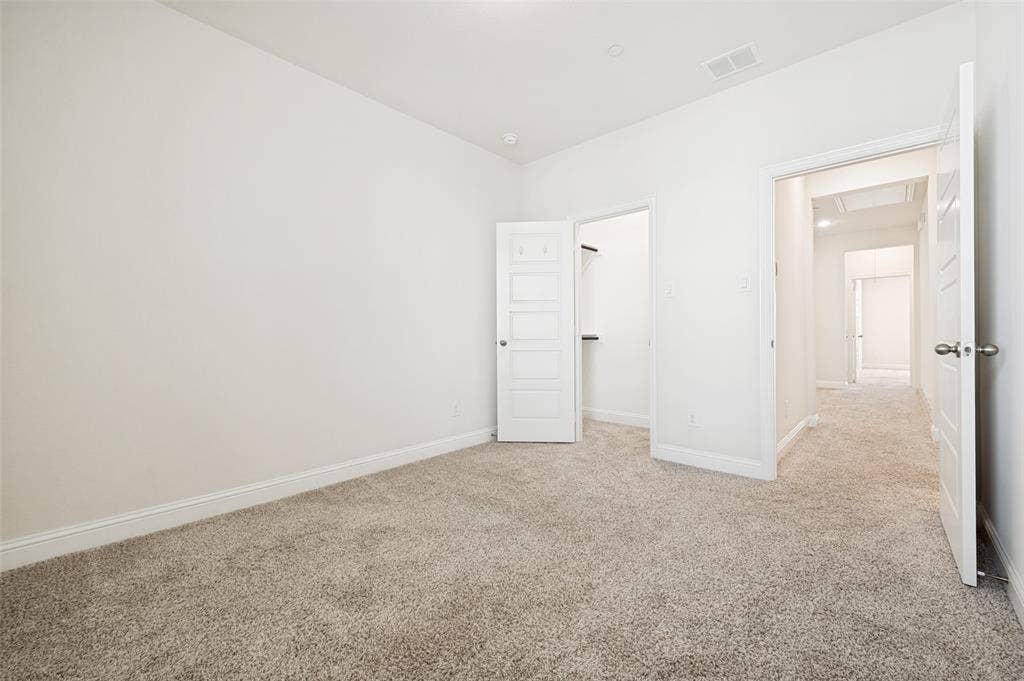 12986 Jk Ojha Street, Farmers Branch, TX 75234 Bright interior space featuring light-toned carpeting and white wall finishes