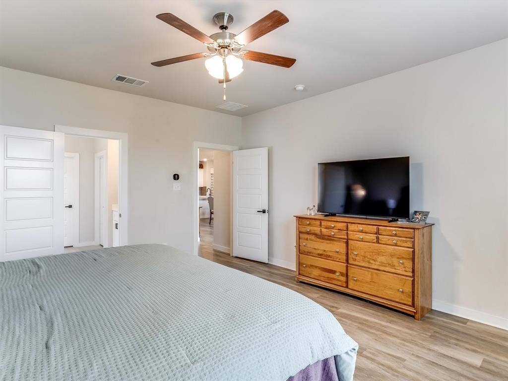 1021 Daylily Drive, Northlake, TX 76226 Bedroom featuring wood-finish flooring, a ceiling fan with integrated lighting, and two panel doors