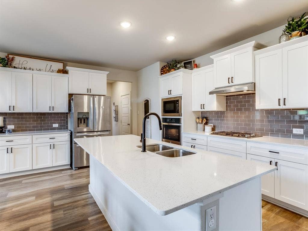 1021 Daylily Drive, Northlake, TX 76226 Modern kitchen featuring a large central island with a double basin sink and gooseneck faucet