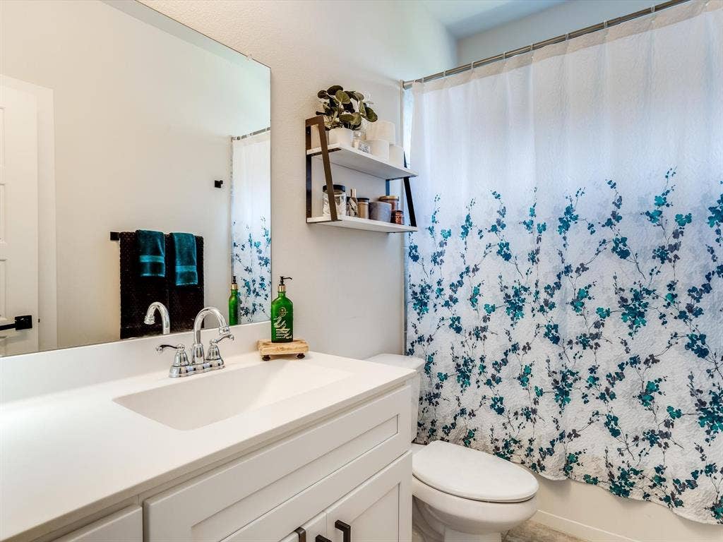 1021 Daylily Drive, Northlake, TX 76226 Bathroom featuring a vanity with a white countertop and integrated sink, chrome faucet, and white cabinetry