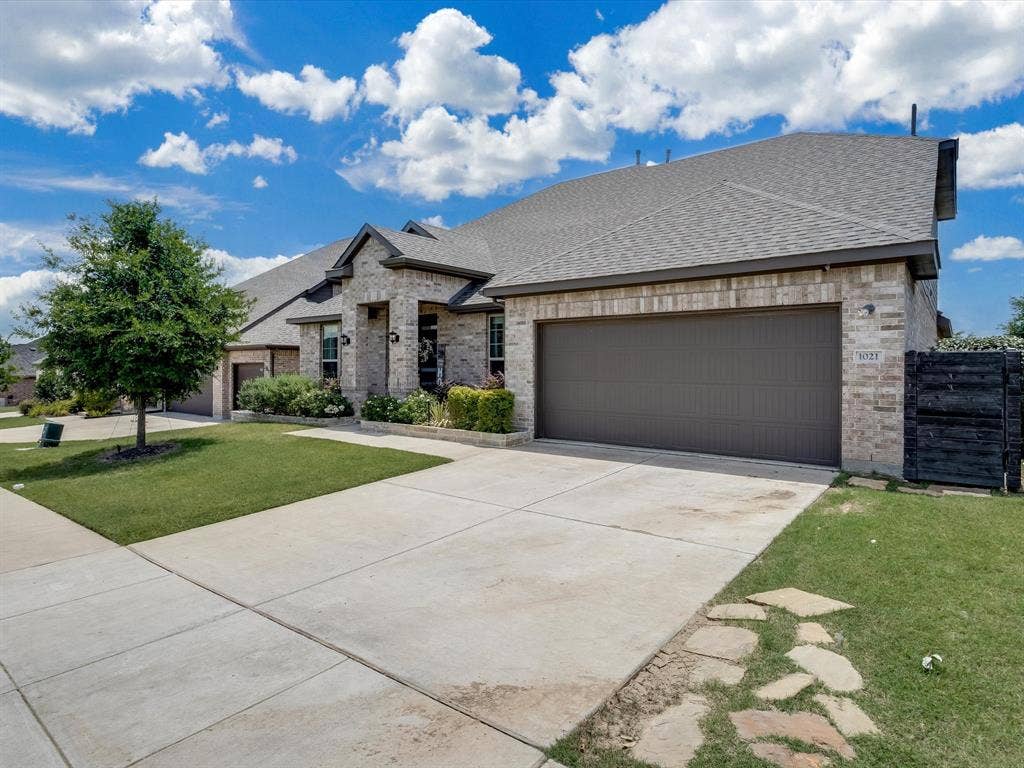 1021 Daylily Drive, Northlake, TX 76226 Brick exterior featuring a gabled roofline, an attached two-car garage, and a concrete driveway