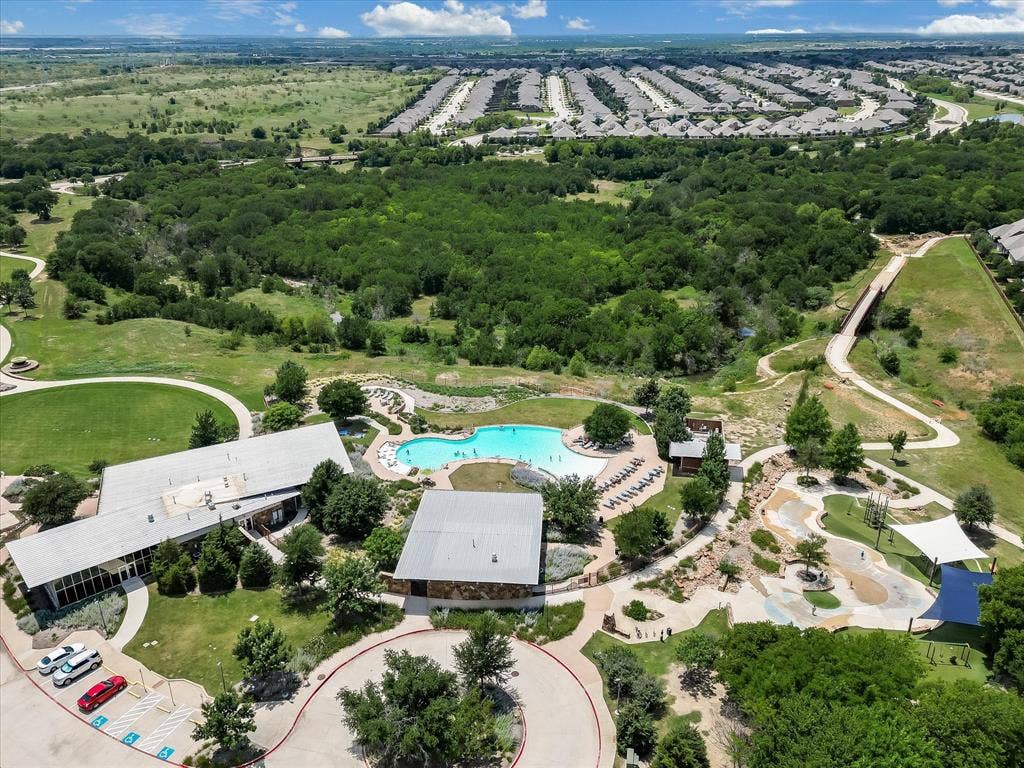 1021 Daylily Drive, Northlake, TX 76226 Expansive community amenities including a large swimming pool, adjacent lounge area with chaise seating, and a dedicated splash pad with shade structures