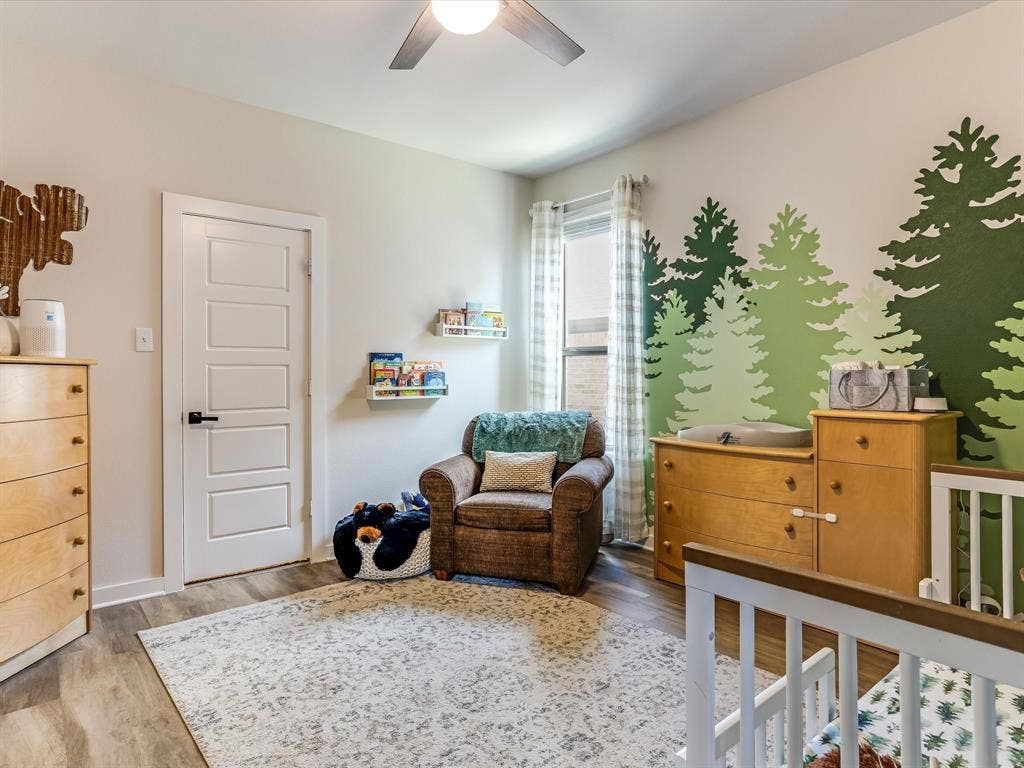 1021 Daylily Drive, Northlake, TX 76226 Room featuring a ceiling fan, wood-finish flooring, a window with curtains, and a five-panel interior door with matte black hardware