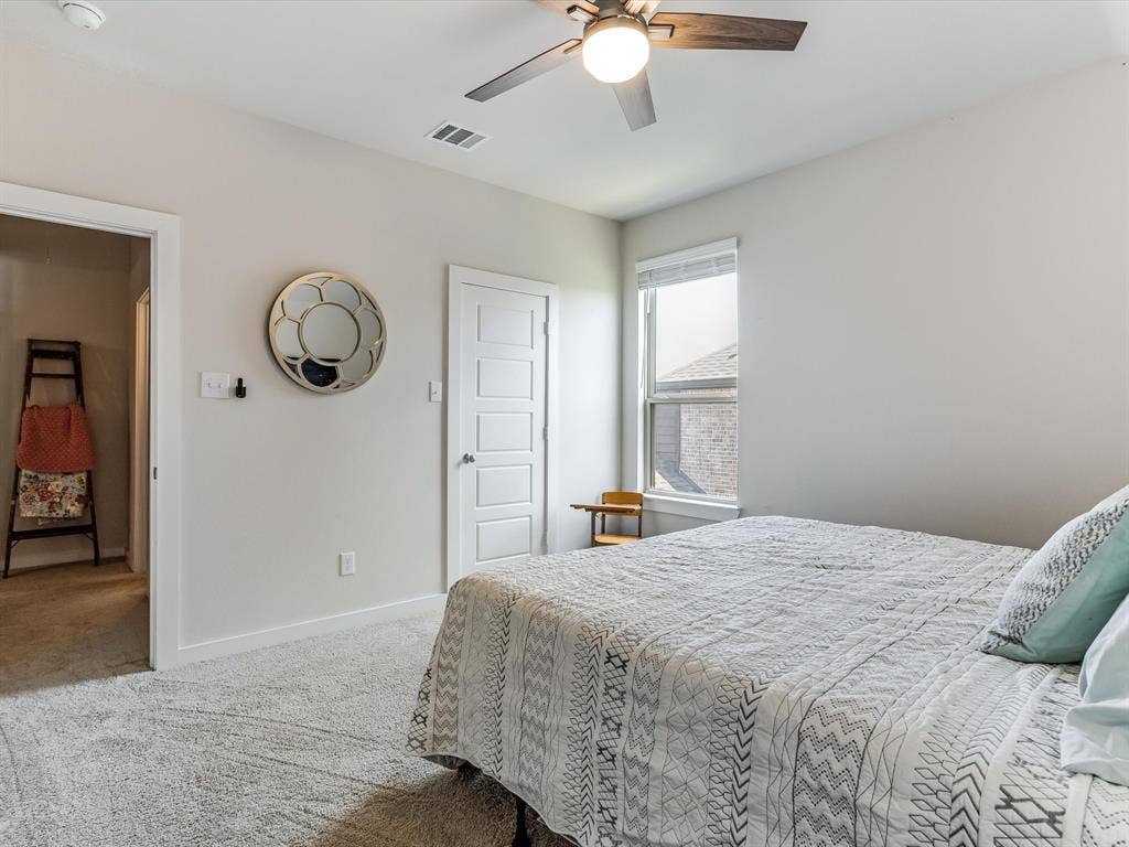 1021 Daylily Drive, Northlake, TX 76226 Carpeted interior space featuring a window with blinds, ceiling fan with integrated lighting, and a white paneled door