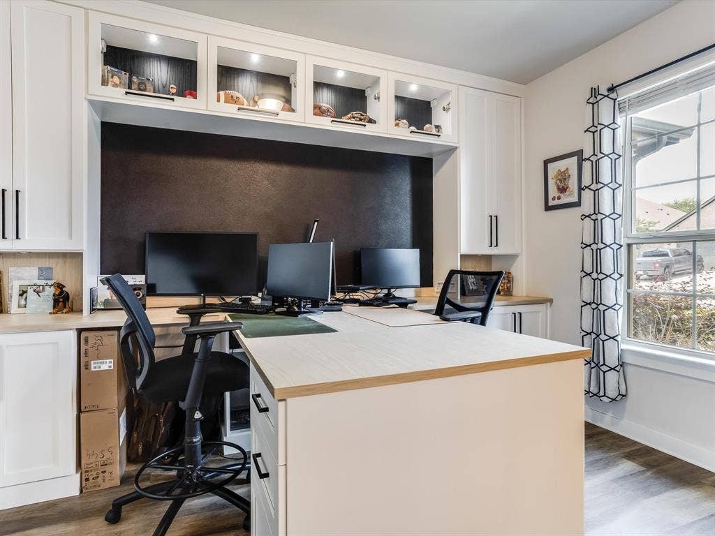 1021 Daylily Drive, Northlake, TX 76226 Dedicated workspace featuring white built-in cabinetry, a dark accent wall, and wood-finish flooring
