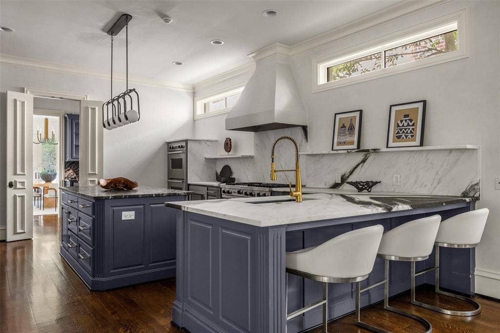 Gourmet kitchen featuring two-tone cabinetry, professional-grade stainless steel appliances, and contrasting countertops