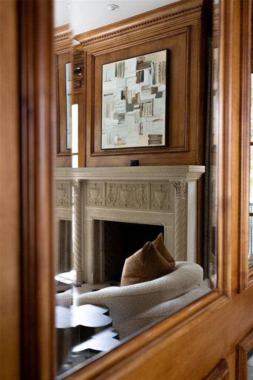 Ornate carved stone fireplace with a dark firebox and decorative wood paneling