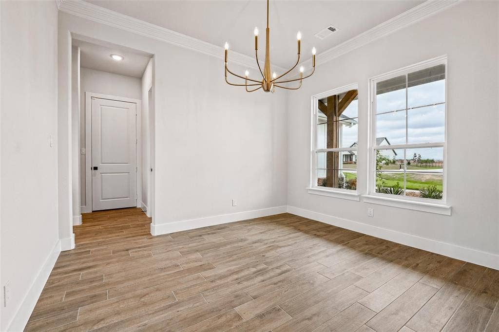 12413 Hornfels Drive, Krum, TX 76249 Wood-look tile flooring, crown molding, and a bronze-finish chandelier
