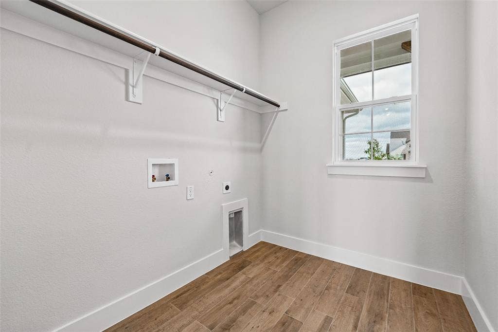 12413 Hornfels Drive, Krum, TX 76249 Laundry area with wood-finish flooring, a single window, and a clothes hanging rod