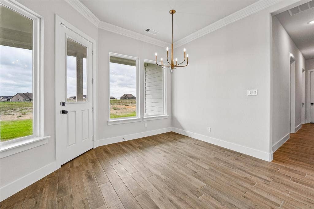 12413 Hornfels Drive, Krum, TX 76249 Wood-finish tile flooring, white walls, and a multi-light brass chandelier